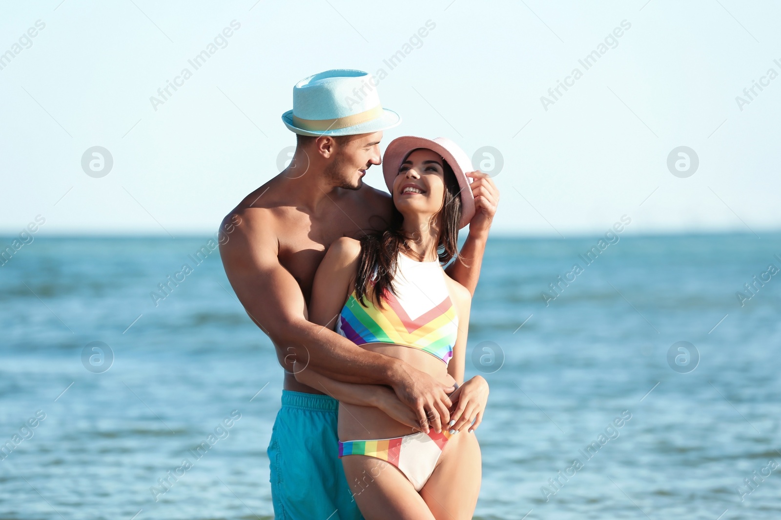 Photo of Happy young couple posing near sea on beach