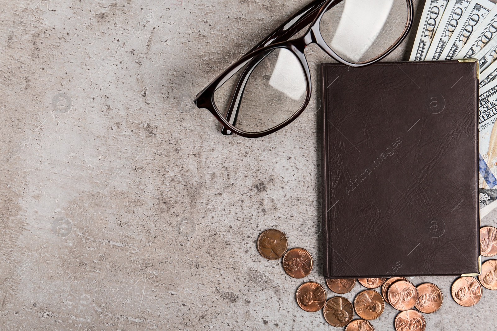 Photo of Pension certificate with American money and glasses on grey stone table, flat lay. Space for text