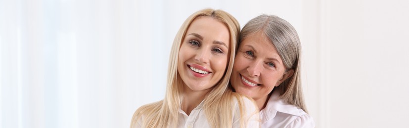 Happy mother and daughter indoors, banner design