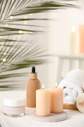 Photo of Spa composition. Burning candles and personal care products on soft white surface