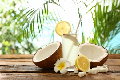 Composition with glass of coconut water and lemon on wooden table