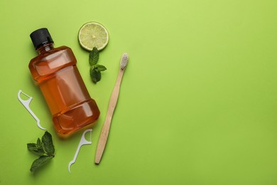 Photo of Flat lay composition with mouthwash and other oral hygiene products on light green background. Space for text