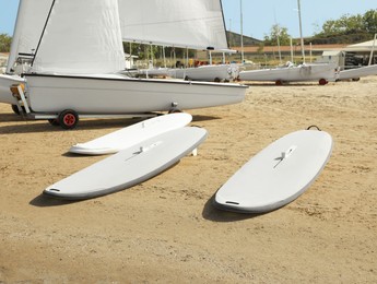 Photo of Seacoast with surf boards and modern yachts on sunny day
