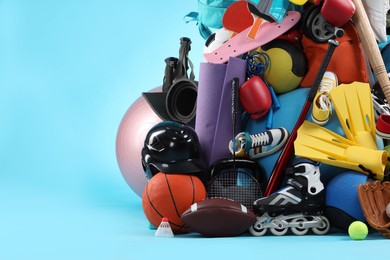 Many different sports equipment on light blue background