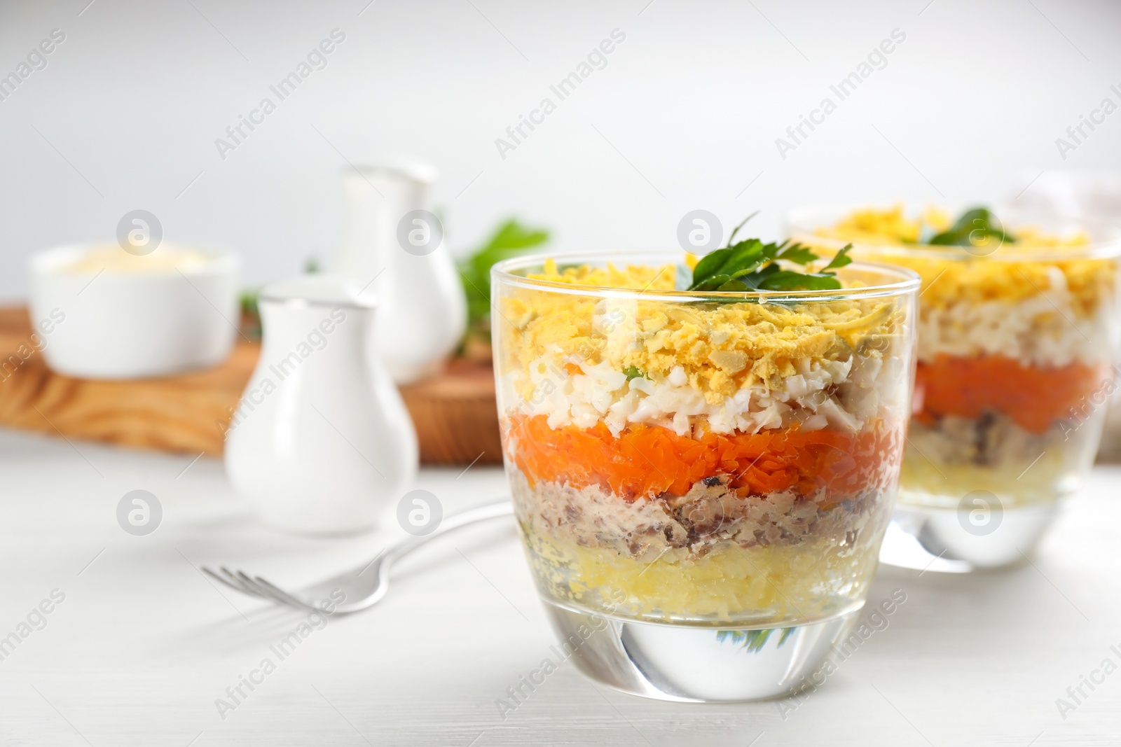 Photo of Traditional russian salad Mimosa served on white table, space for text