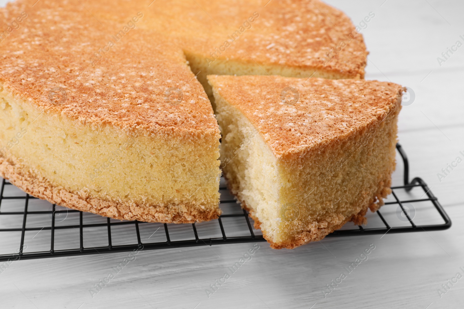 Photo of Tasty sponge cake on white wooden table, closeup