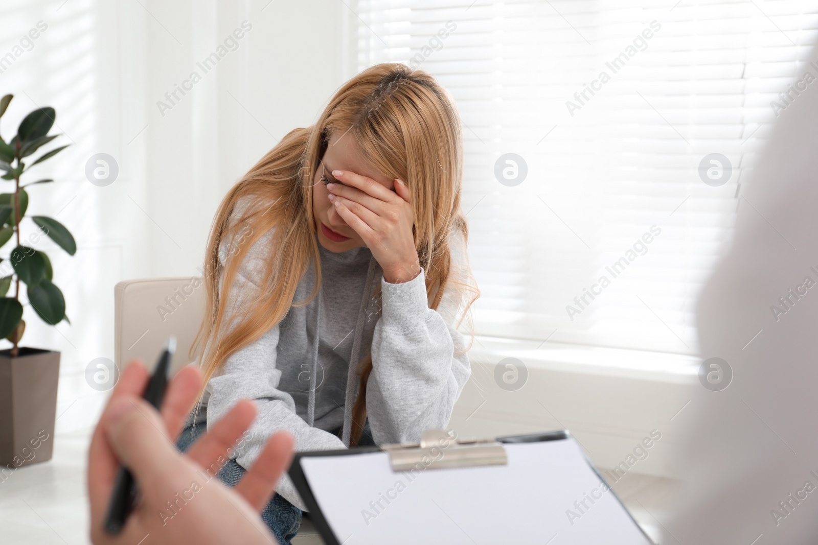 Photo of Psychotherapist working with drug addicted young woman indoors