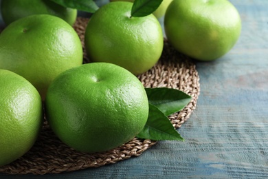 Photo of Fresh ripe sweetie fruits on blue wooden table