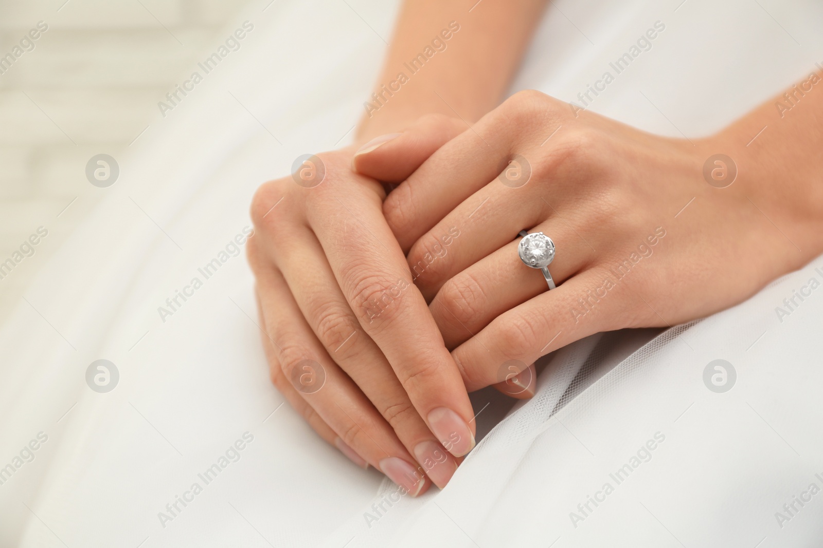 Photo of Young bride wearing beautiful engagement ring, closeup