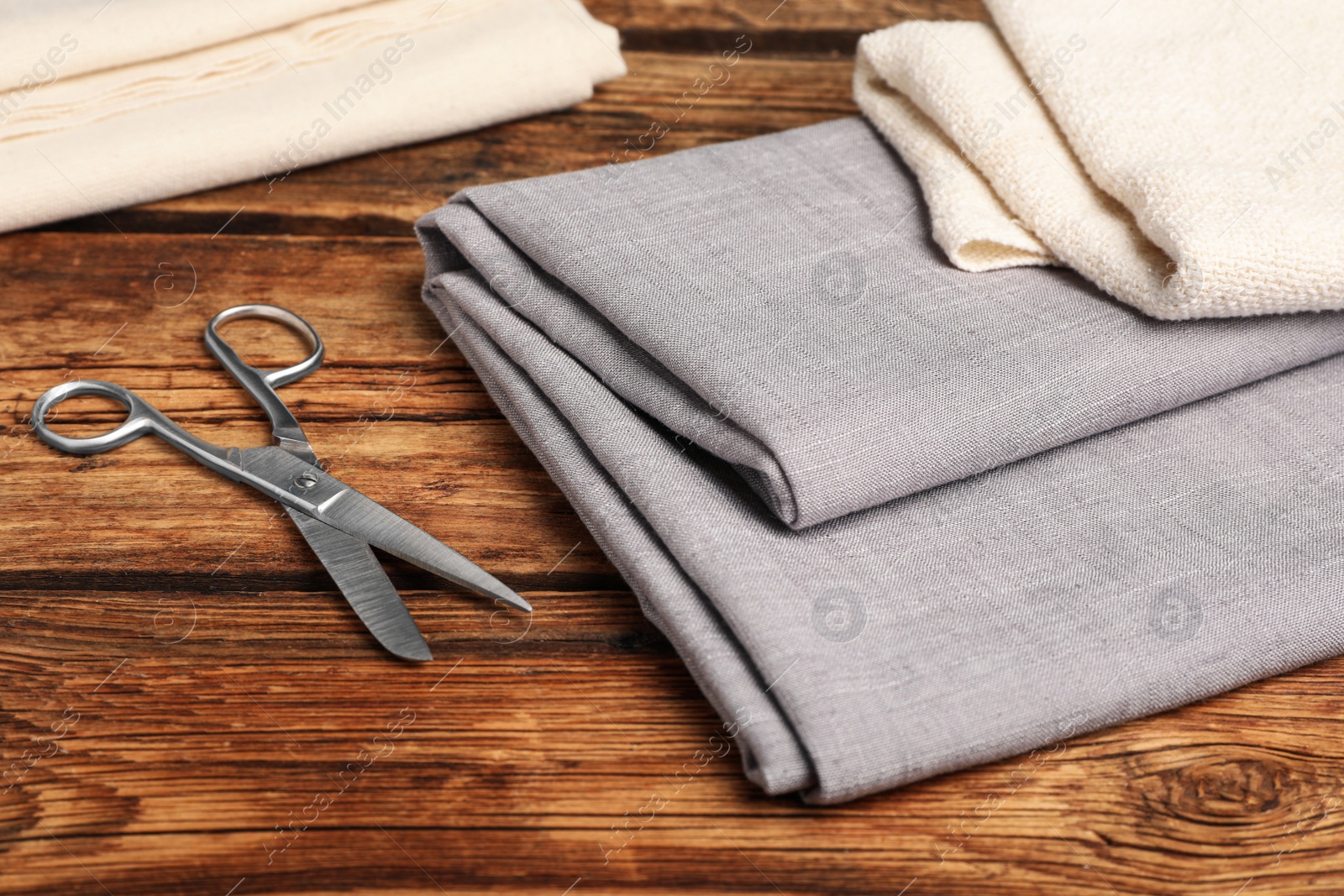 Photo of Hemp cloths and scissors on wooden table