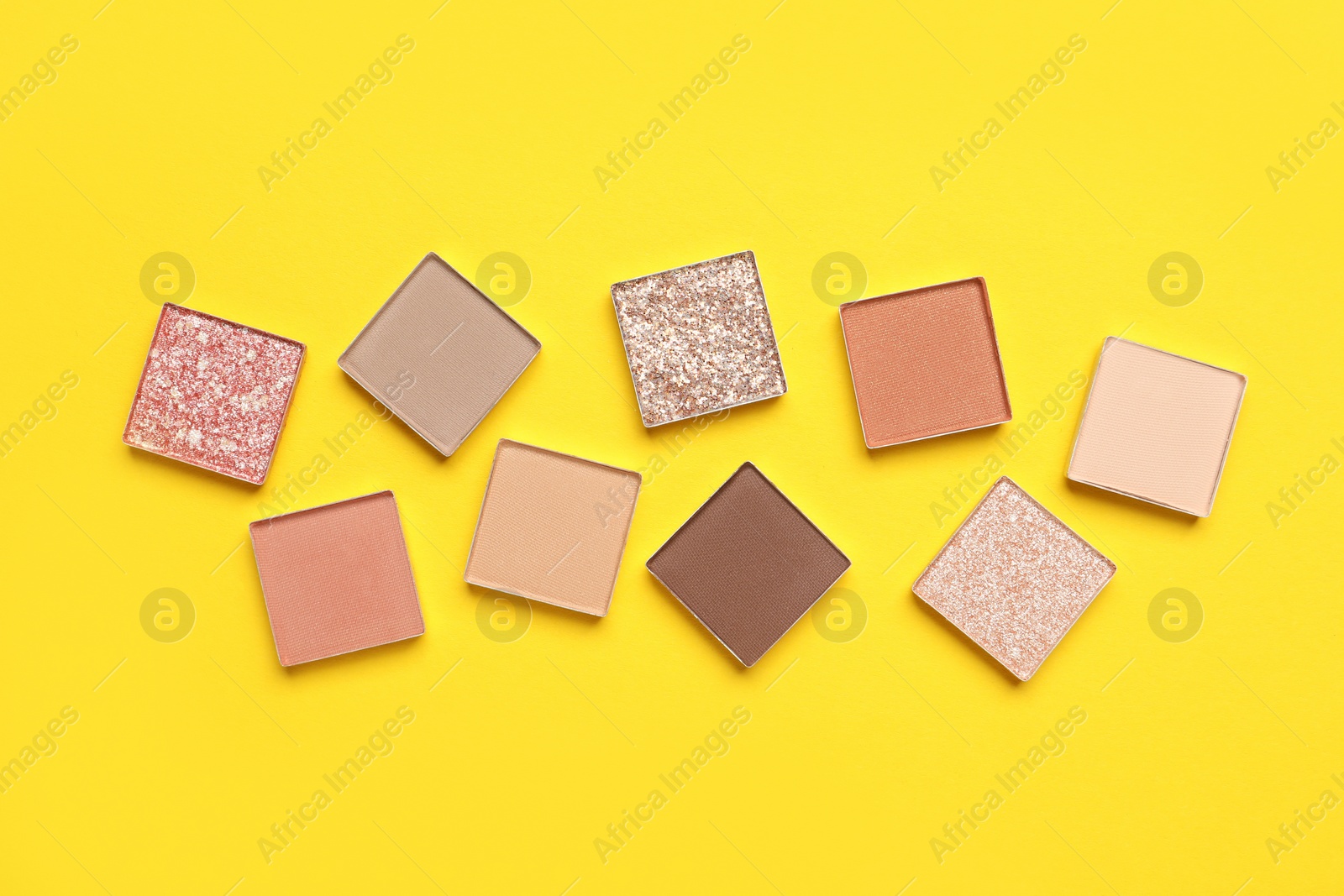 Photo of Beautiful eye shadow refill pans on yellow background, flat lay