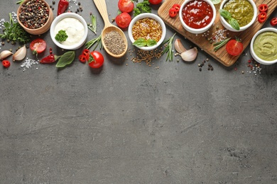 Photo of Flat lay composition with different sauces and space for text on gray background