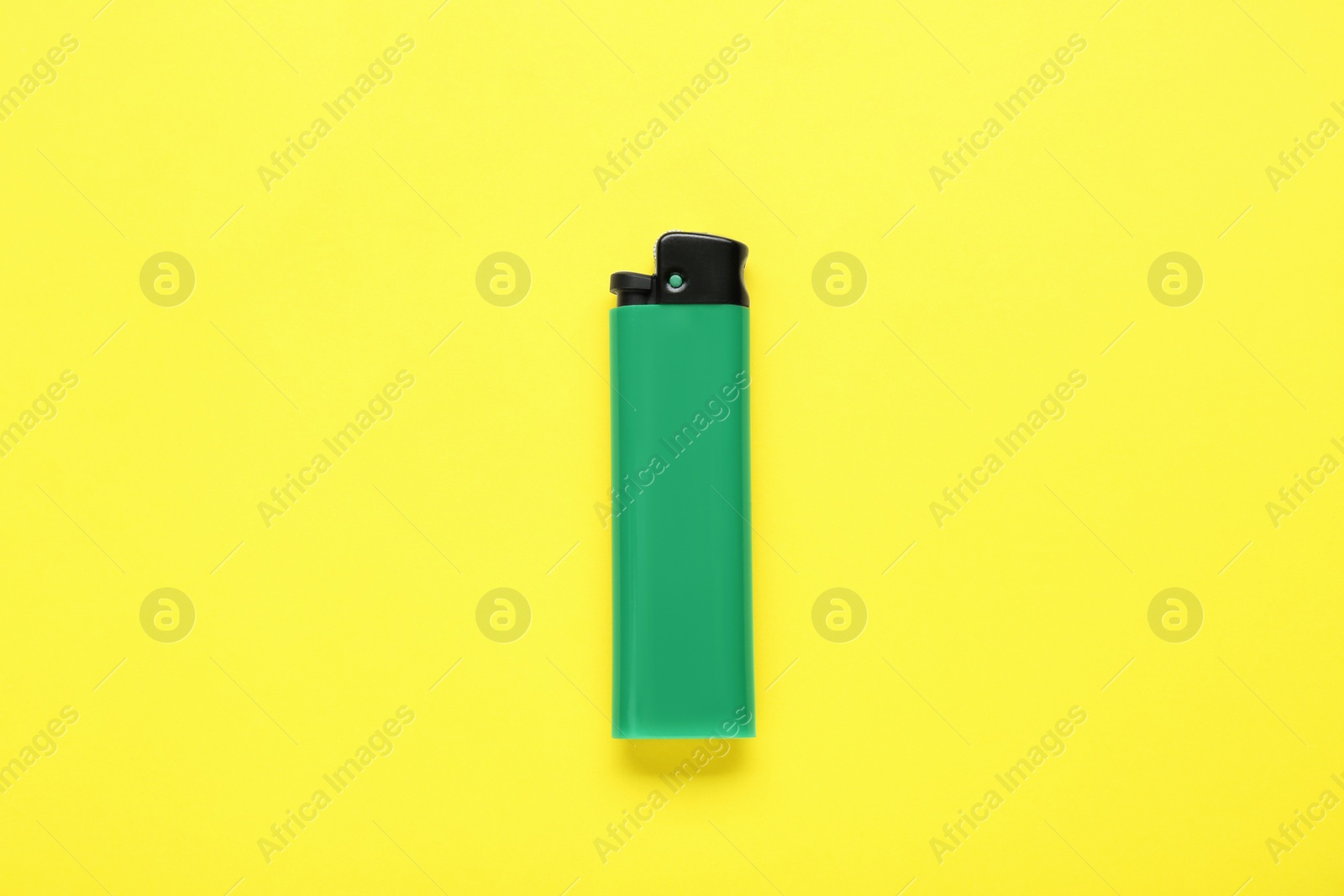 Photo of Stylish small pocket lighter on yellow background, top view