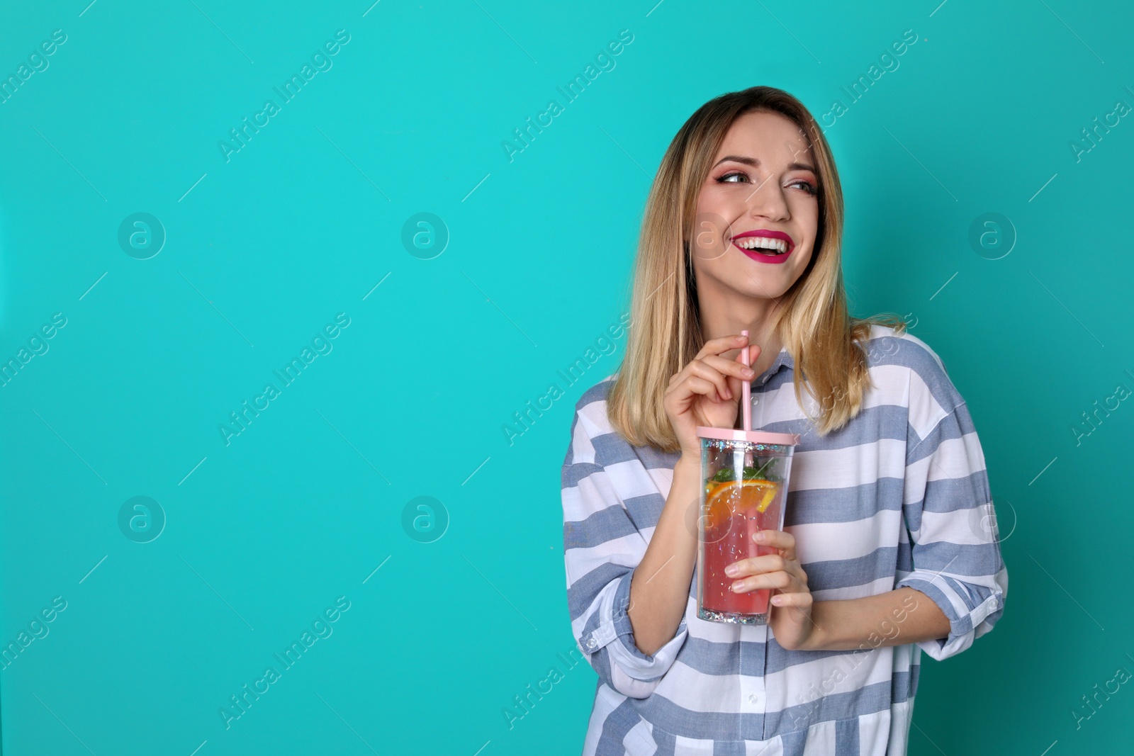 Photo of Young woman with tasty lemonade on color background. Natural detox drink