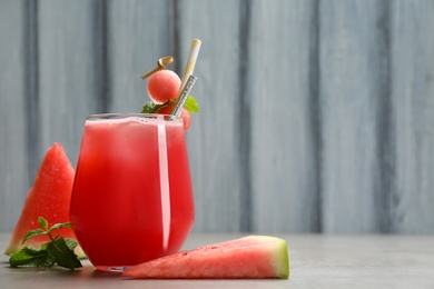 Photo of Delicious fresh watermelon drink on grey table. Space for text