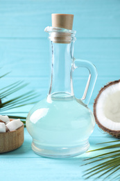 Photo of Coconut oil on light blue wooden table, closeup