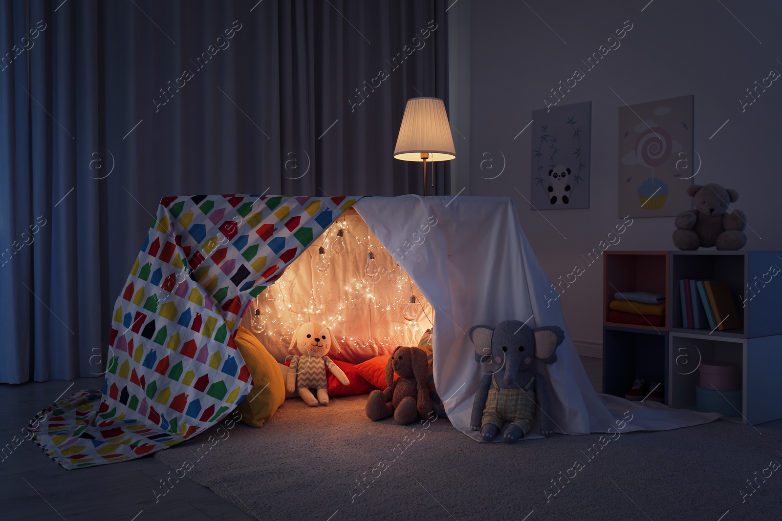 Photo of Play tent decorated with festive lights in modern child's room