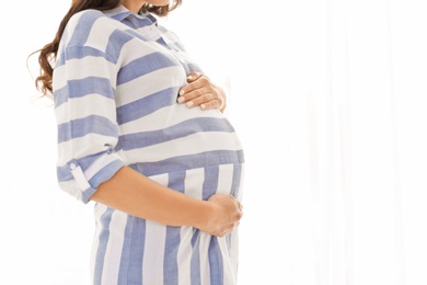 Beautiful pregnant woman on light background