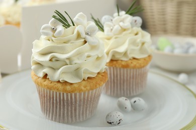 Photo of Tasty Easter cupcakes with vanilla cream on table, closeup