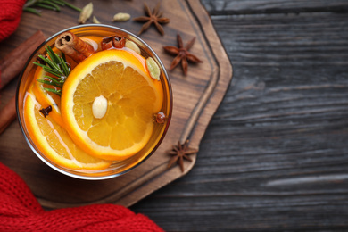 Aromatic mulled wine on black wooden table, top view. Space for text