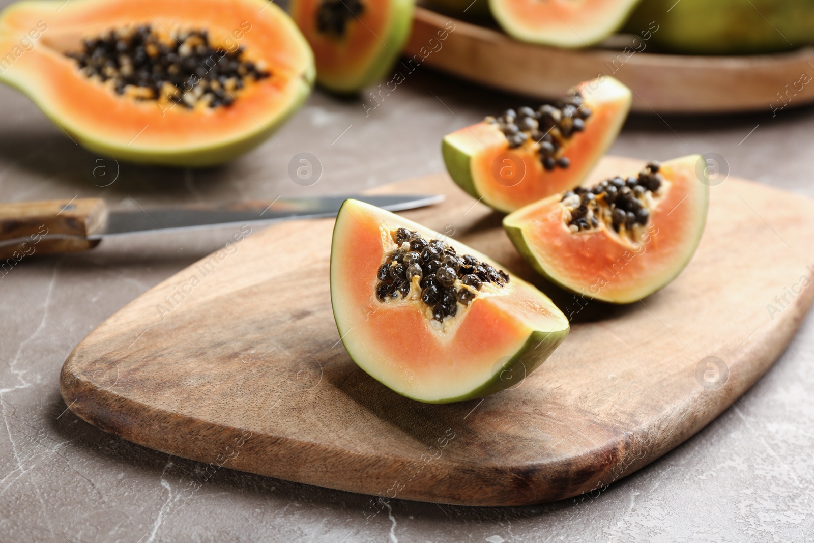 Photo of Fresh cut papaya on grey table. Exotic fruit