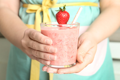 Photo of Woman holding tasty strawberry smoothie, closeup view