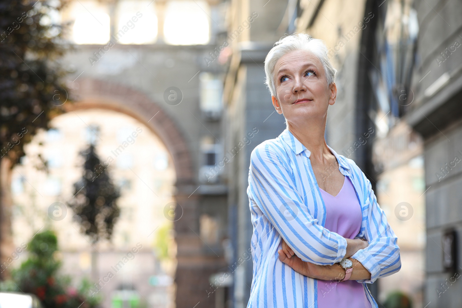 Photo of Happy mature woman on city street, space for text. Smart aging