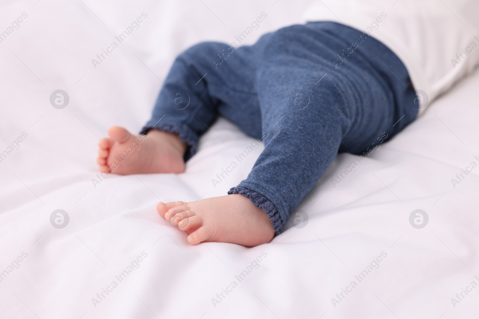 Photo of Newborn baby lying on white blanket, closeup