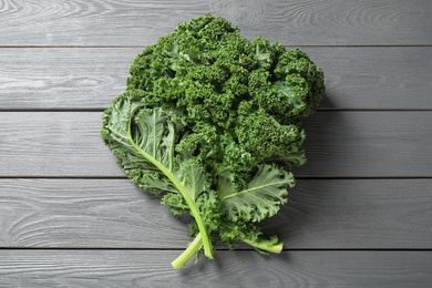 Fresh kale leaves on light grey wooden table, top view