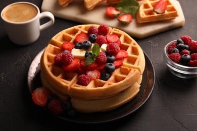 Photo of Tasty Belgian waffles with fresh berries, cheese and cup of coffee on black table, closeup