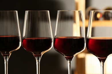 Photo of Glasses of red wine in cellar, closeup. Expensive drink