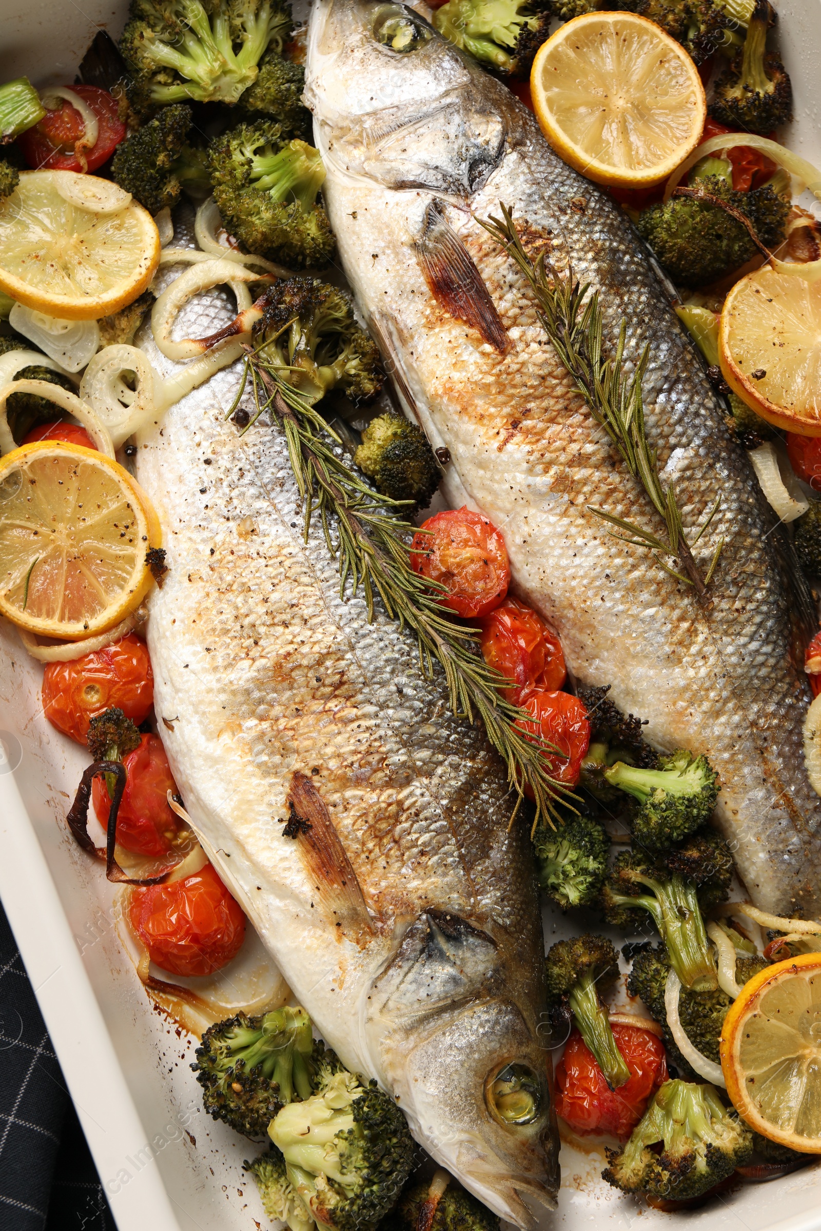 Photo of Delicious fish with vegetables and lemon in baking dish, flat lay