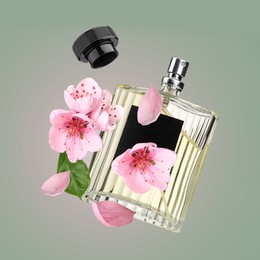 Bottle of perfume and sakura flowers in air on color gradient background