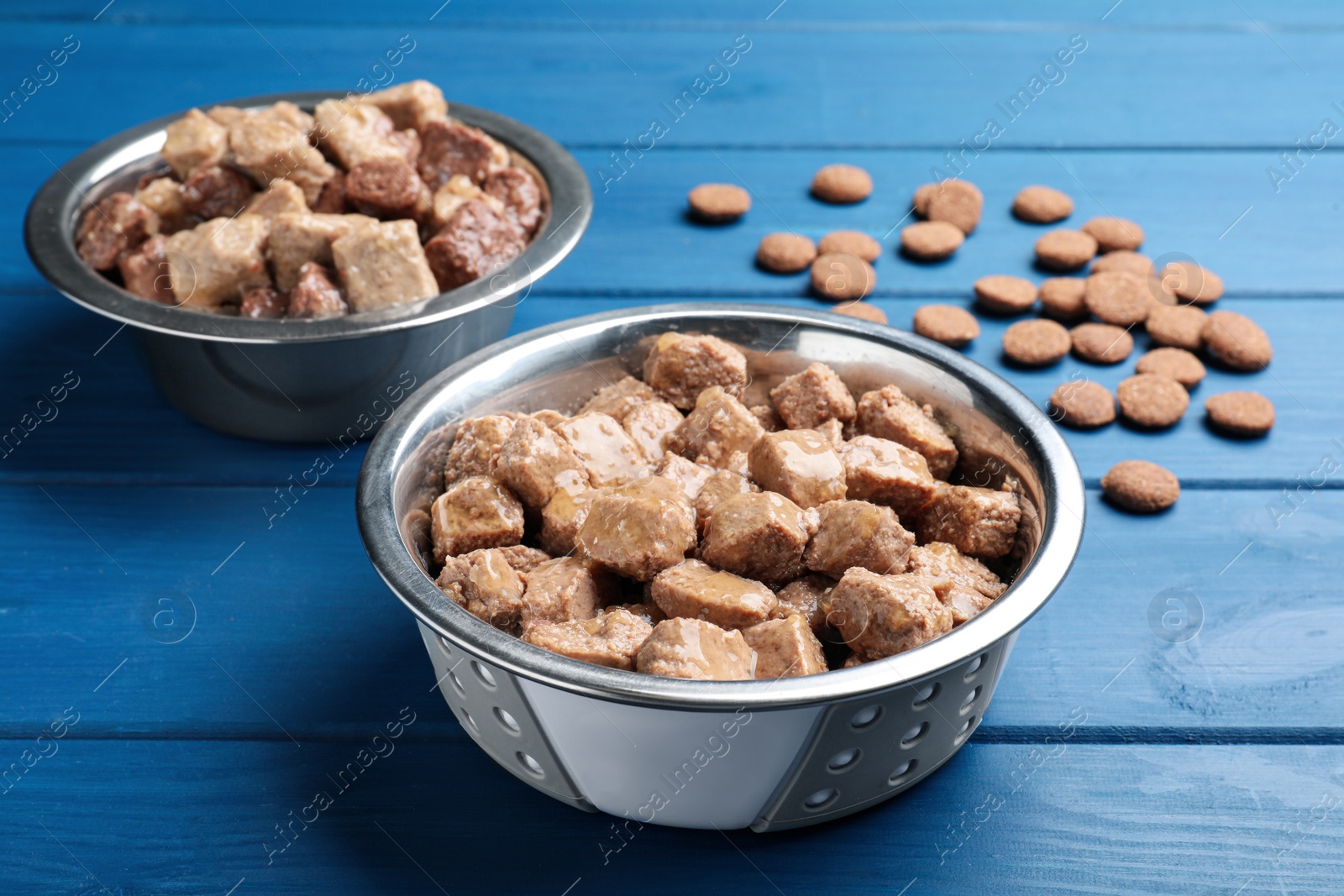 Photo of Wet and dry pet food on blue wooden table