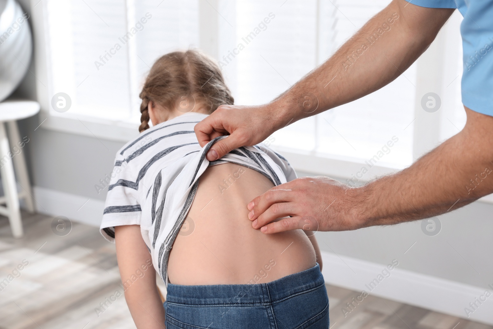 Photo of Orthopedist examining child's back in clinic, closeup. Scoliosis treatment