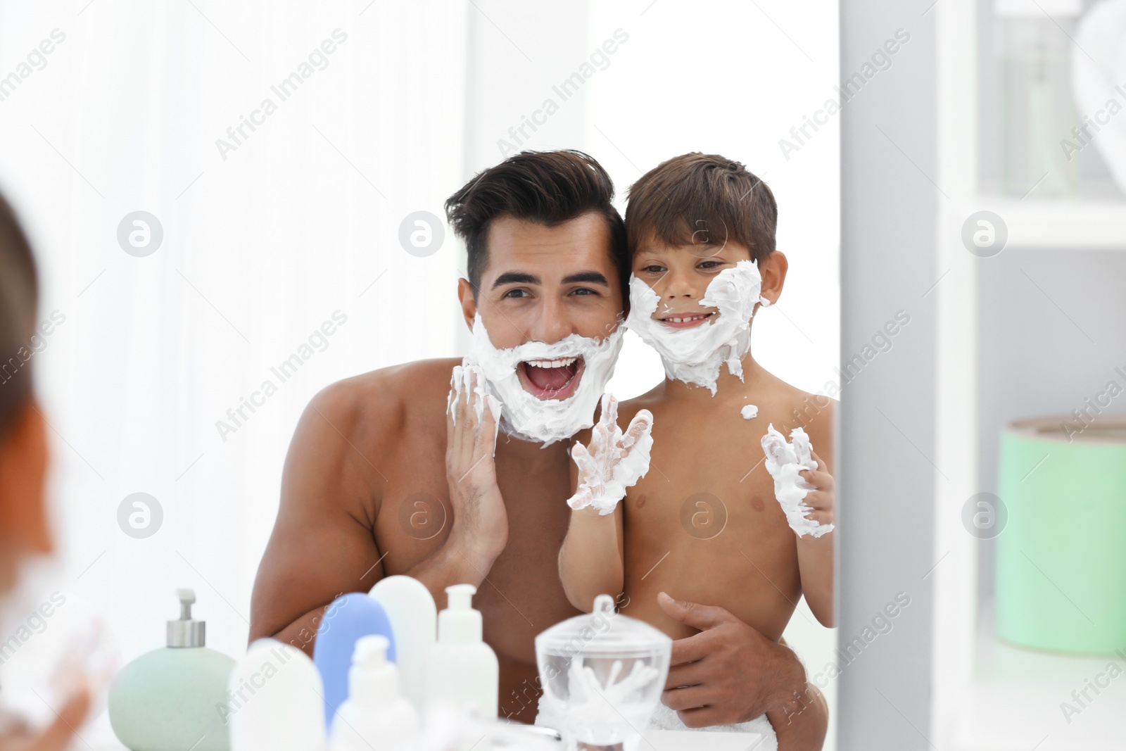 Photo of Father and son having fun while applying shaving foam in bathroom