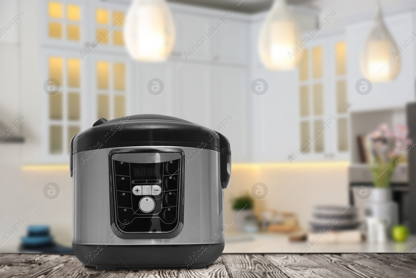 Image of Modern electric multi cooker on wooden table in kitchen. Space for design