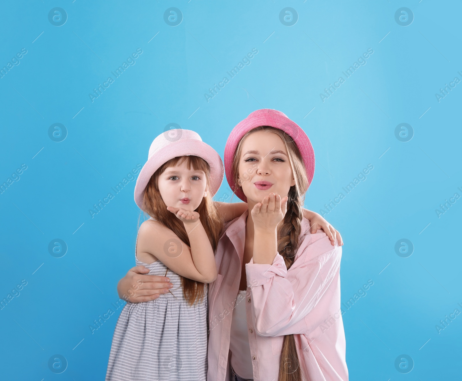 Photo of Happy woman and daughter in stylish clothes on color background