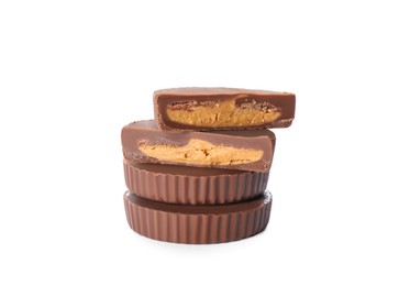 Photo of Cut and whole delicious peanut butter cups on white background