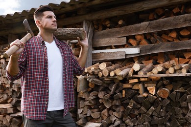 Photo of Man with ax and log near wood pile outdoors