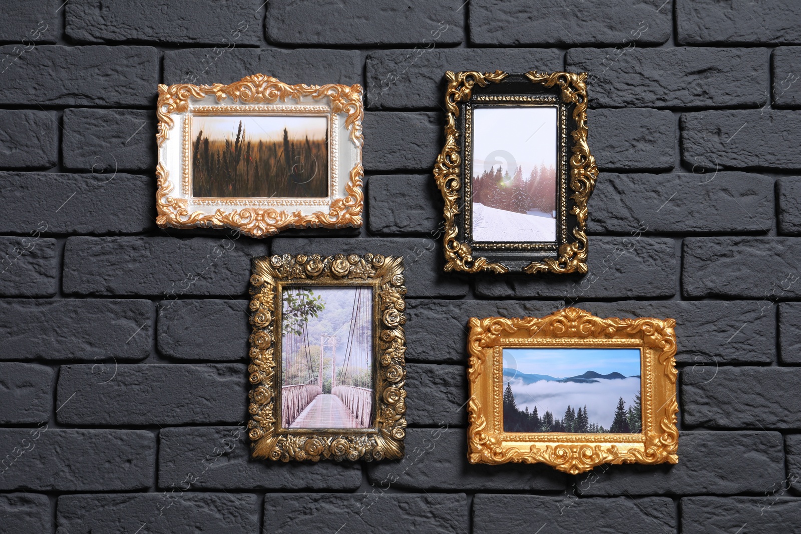 Photo of Vintage frames with photos of beautiful landscapes hanging on dark brick wall