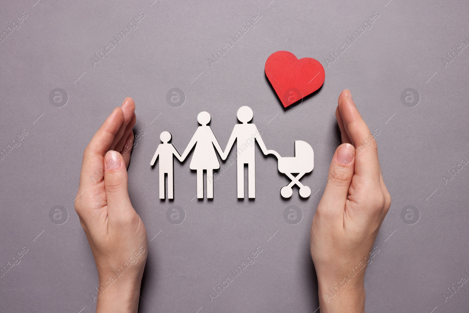 Photo of Woman protecting figures of family and heart on lilac background, top view. Insurance concept