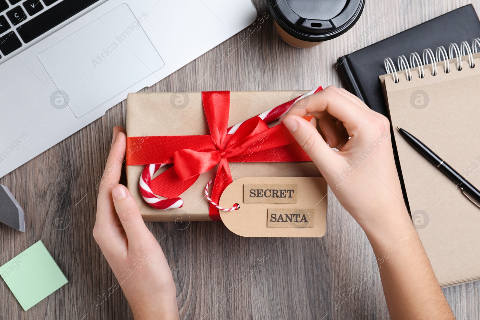 Photo of Woman opening present from secret Santa at workplace, top view