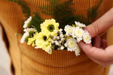 Photo of Woman wearing dress with flowers in pocket, closeup