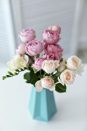 Vase with beautiful flowers on table indoors