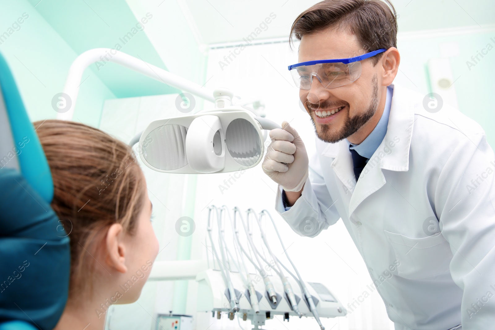 Photo of Professional dentist working with little patient in modern clinic