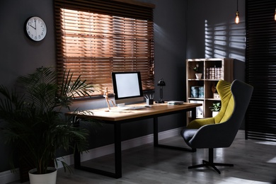 Photo of Stylish room interior with modern computer and comfortable office chair