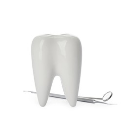 Tooth shaped holder and dentist's tools on white background