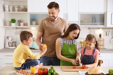 Happy family with children together in kitchen