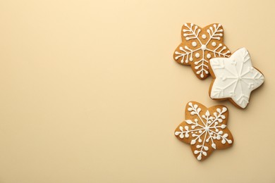 Photo of Tasty Christmas cookies with icing on beige background, flat lay. Space for text